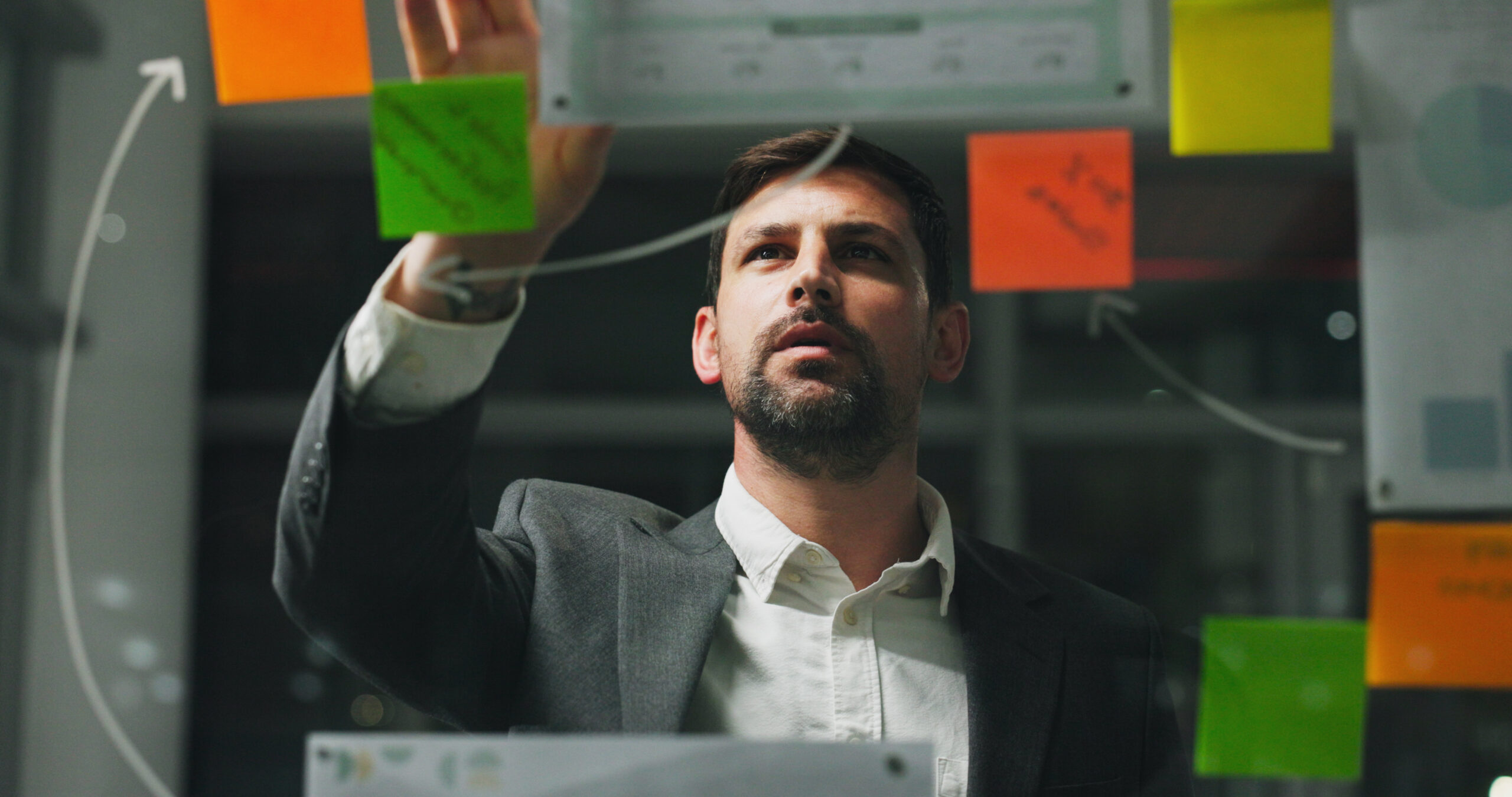 Man wearing suit looking at sticky notes